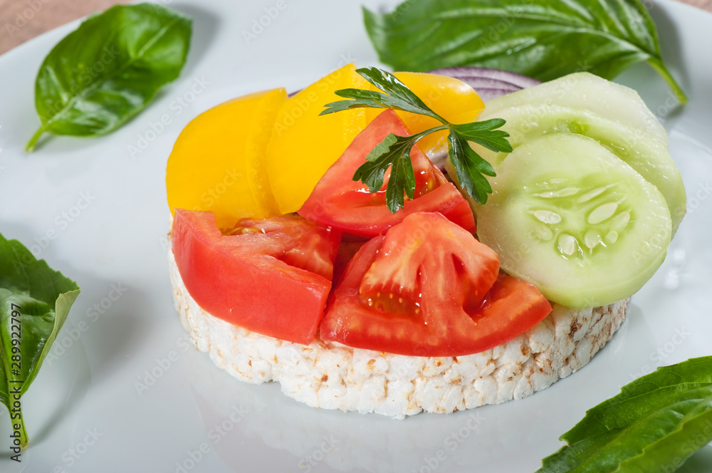Rice cake with vegetables, tomato, cucumber and sweet pepper and onions.