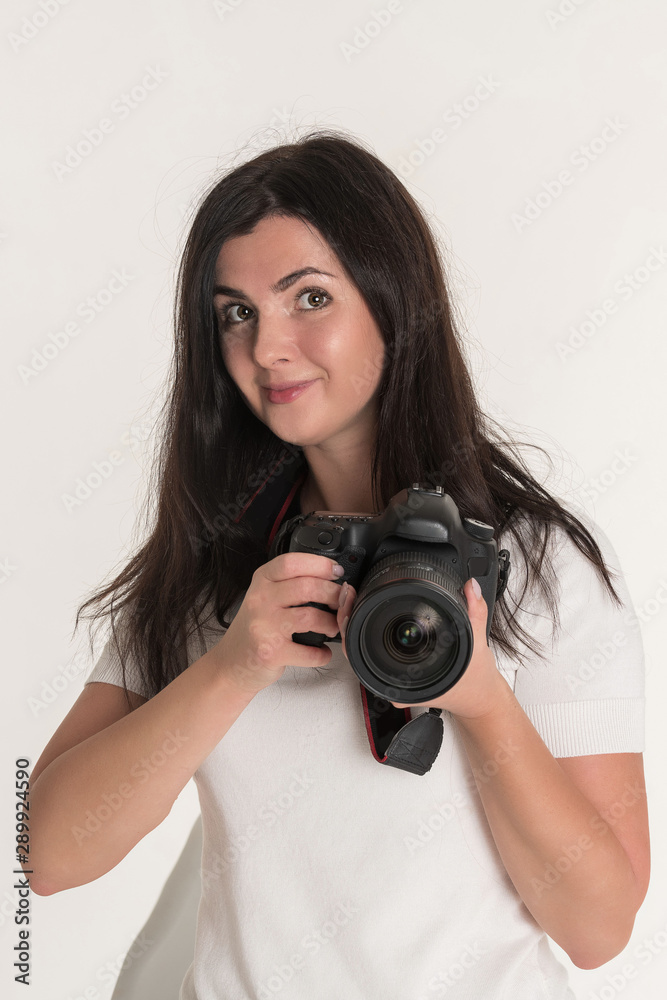 Young brunette woman - professional photographer with DSLR camera on white background