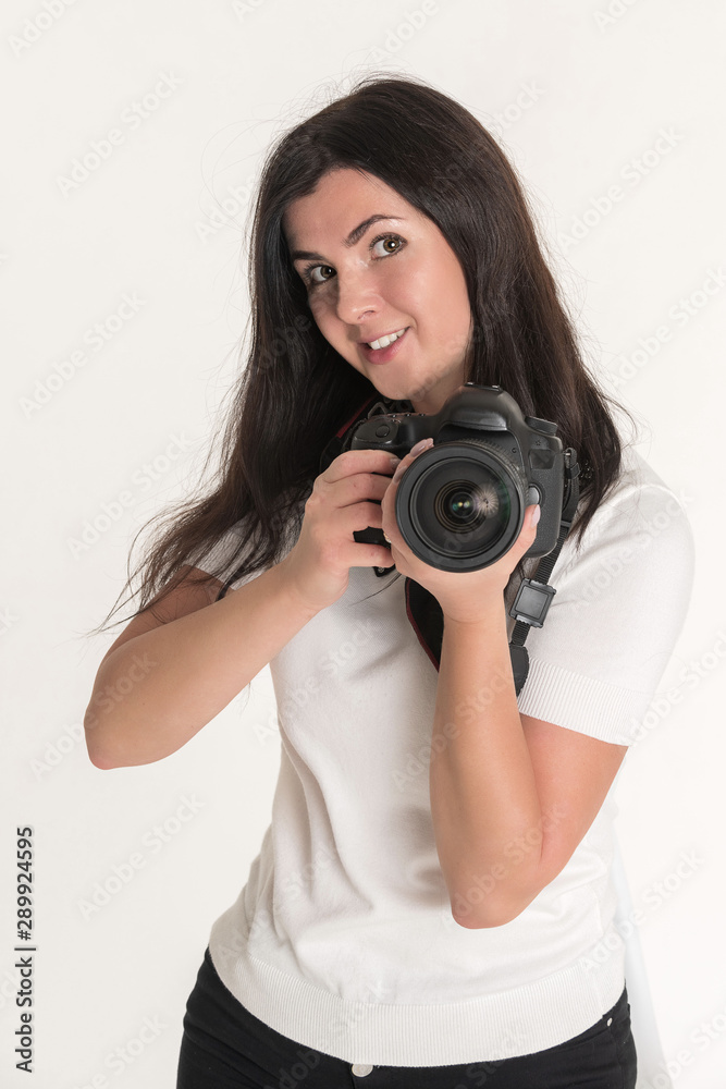 Young brunette woman - professional photographer with DSLR camera on white background Young brunette woman - professional photographer with DSLR camera on white background