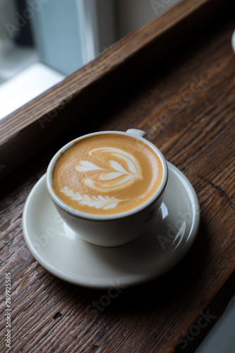 Taza de café con leche sobre una mesa de madera rústica en una cafeteria photo