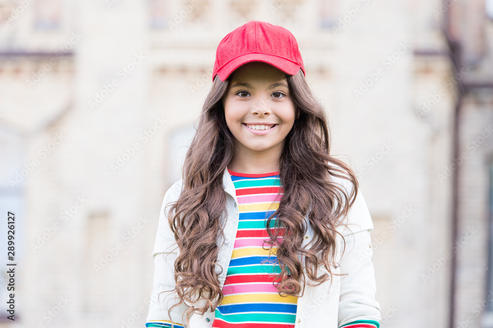 This girl is hipster. Happy little hipster with long curly hair wearing baseball  cap outdoor. Cute small hipster smiling with fashionable look. Adorable  child in hipster style Stock Photo | Adobe Stock