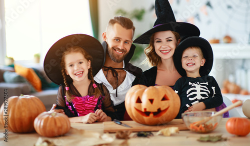 happy family mother father and children in costumes on Halloween.