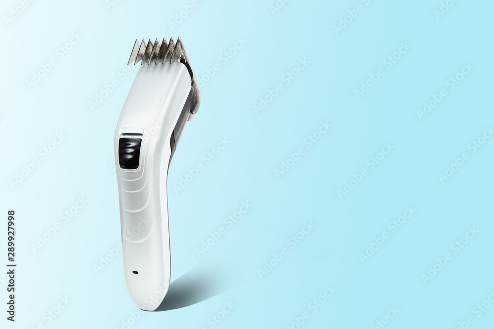 Hair clipper on a pastel blue background. The concept of cutting, improving the appearance. Going to the hairdresser, cutting hair at home. Taking care of appearance.