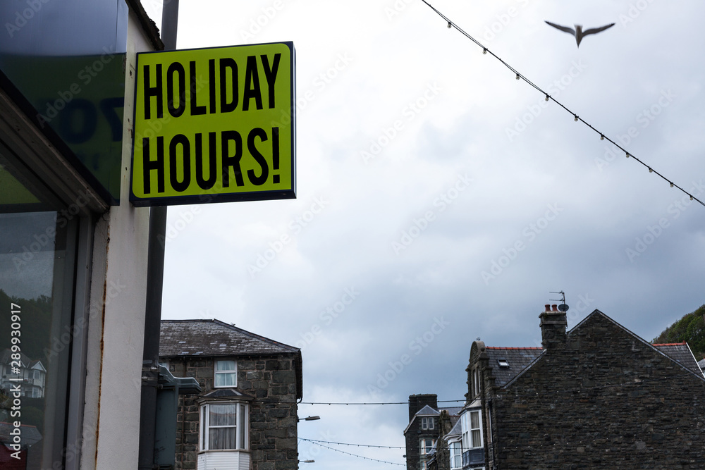Writing note showing Holiday Hours. Business concept for Overtime work on for employees under flexible work schedules Green ad board on the street with copy space for advertisement