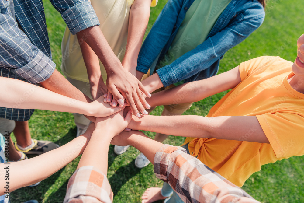 Fototapeta premium cropped view of multiethnicl children putting hands together
