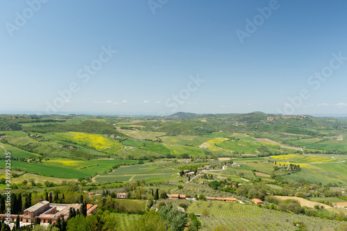 Tuscan countryside with farms and green grass, as seen from above