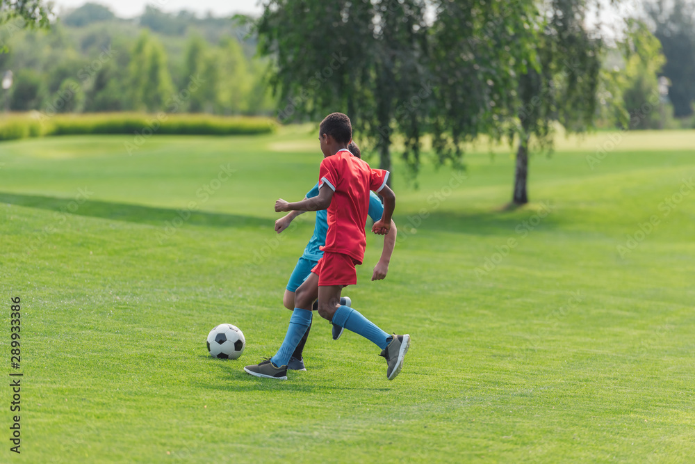 african american boy playing football with friend african american boy playing football with friend