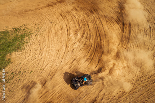 Aerial view of Quad bikes driving in the sand .