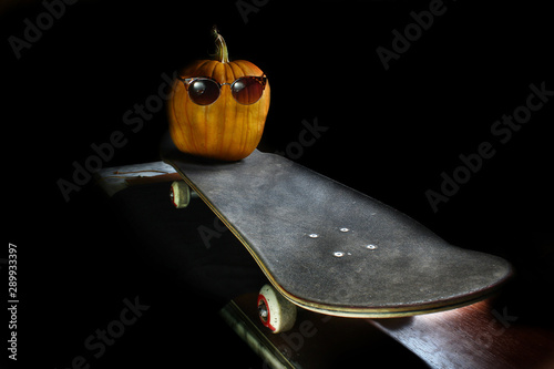 halloween pumpkin with glasses on a skateboard  