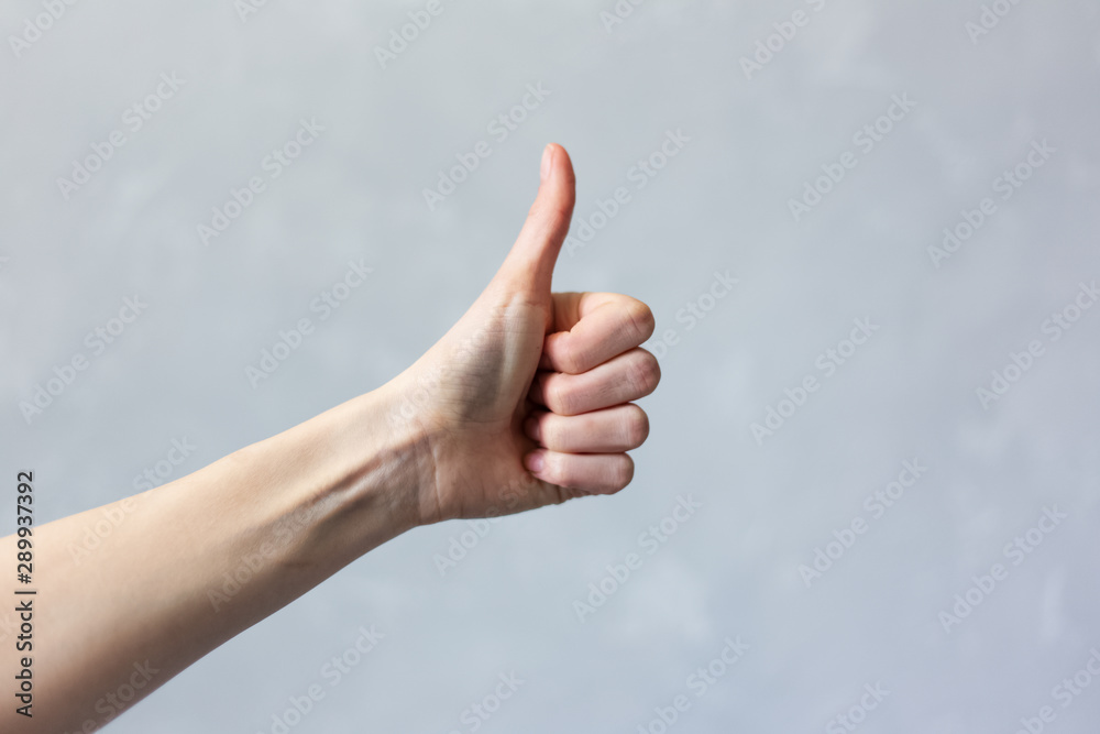 Close-up of female hand show thumb up, on white background. Close-up of female hand show thumb up, on white background.