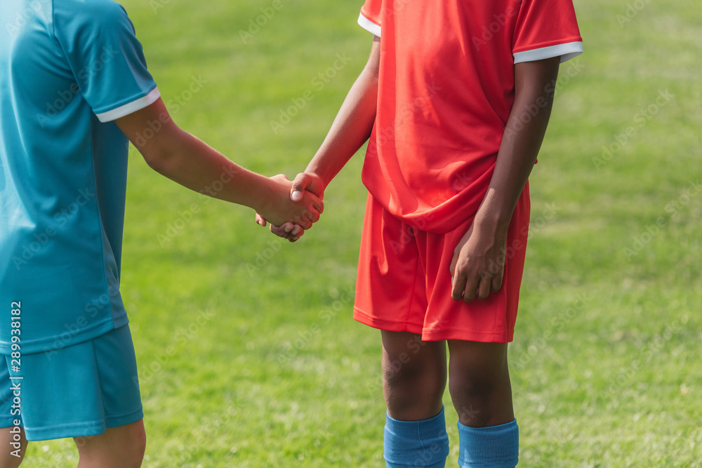 cropped view of multicultural kids shaking hands cropped view of multicultural kids shaking hands