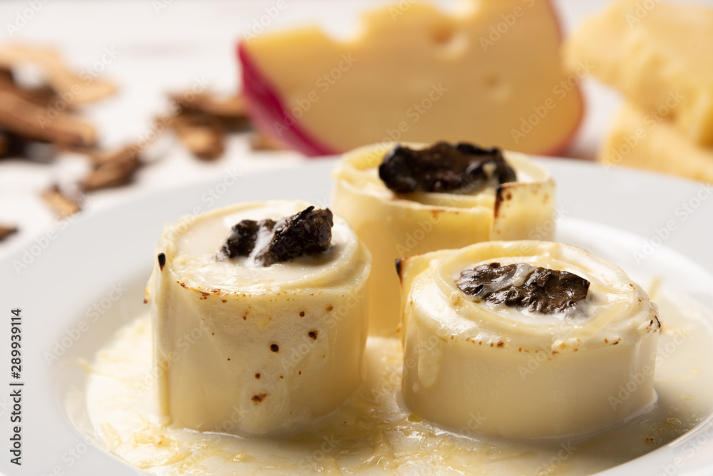 Homemade rondelli with four cheese and mushuroom sauce in white plate on rustic white wooden table background, soft light Homemade rondelli with four cheese and mushuroom sauce in white plate on rustic white wooden table background, soft light