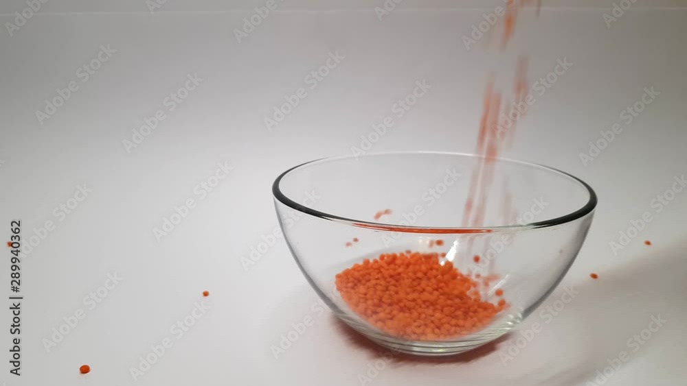 Orange beans poured into transparent glassware, on white background. Orange beans poured into transparent glassware, on white background.