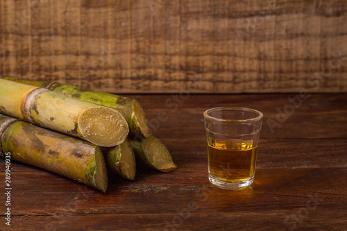 Cachaça is the name of a typical alcoholic drink produced in Brazil maked with sugarcane. Traditional drink from Brazil on wooden table