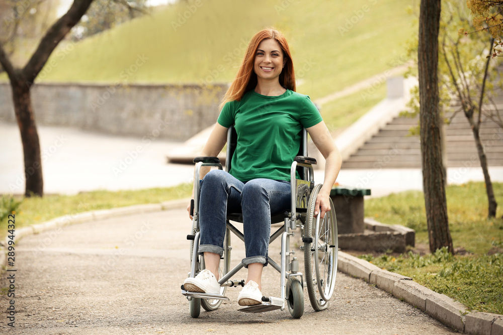 Young woman in wheelchair at park on sunny day Young woman in wheelchair at park on sunny day