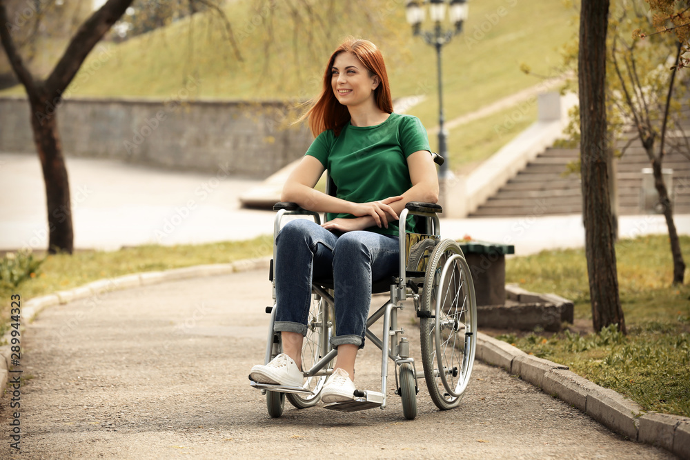 Young woman in wheelchair at park on sunny day Young woman in wheelchair at park on sunny day