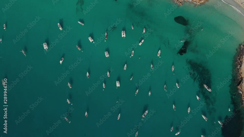 Aerial View of many yachts in a bay on Formentera island. Cala Saona bay drone footage. Yachting in the Balearic islands