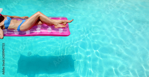 Lower torso or woman in bikini lounging in pool