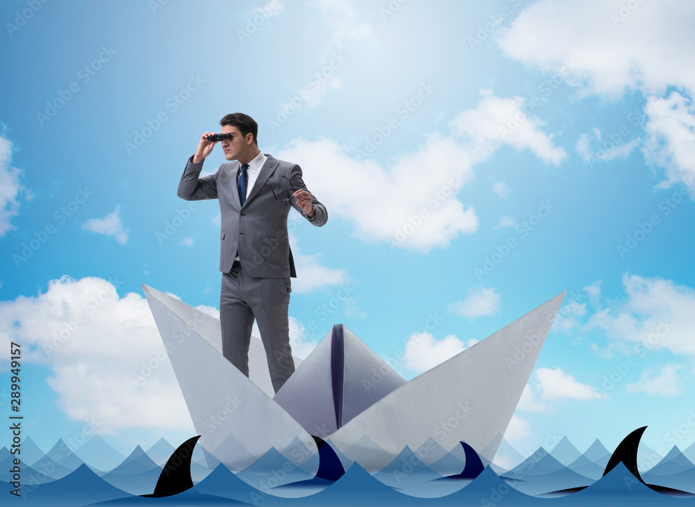 Obraz premium Businessman looking into future with binoculars in paper ship bo