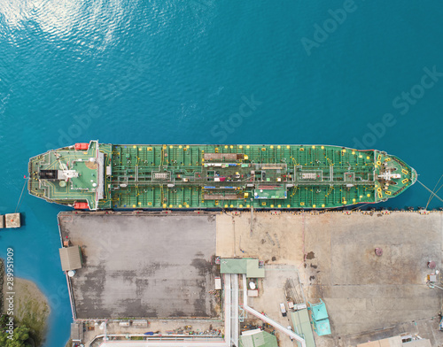 Aerial top view Oil ship tanker at loading dock from refinery on the sea. photo