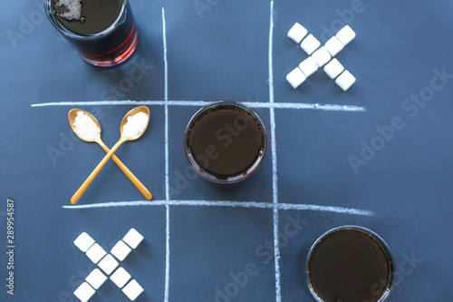 Creative composition with glasses of cola and sugar on grey background photo