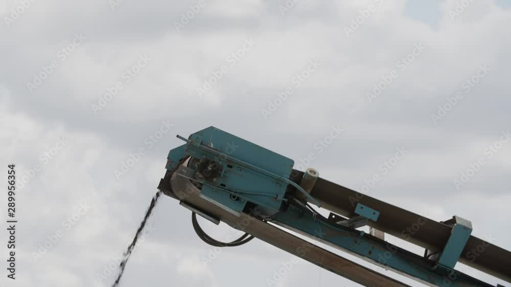 Industrial conveyor belt transporting rocks working at factory outdoors, building industry Industrial conveyor belt transporting rocks working at factory outdoors, building industry