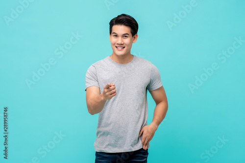 Smiling young man model pointing his finger in front of camera photo