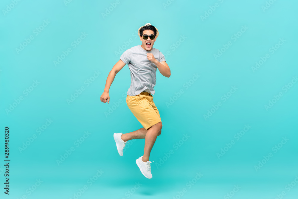 Amazed handsome Asian tourist man jumping