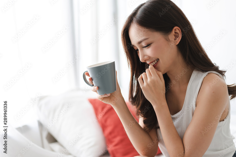 Woman drinking coffee in bedroom in the morning Woman drinking coffee in bedroom in the morning