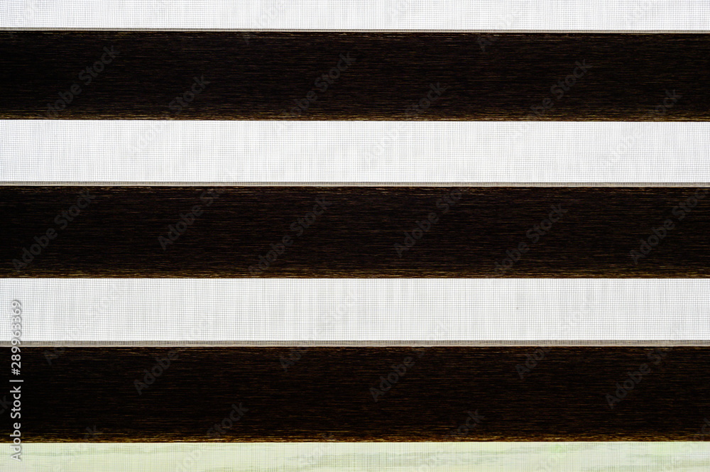View down the side of a two fabric light filtering shade in open position View down the side of a two fabric light filtering shade in open position