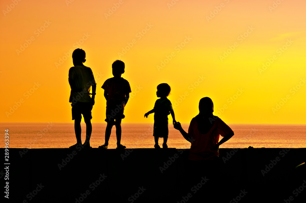 Scenic seascape Beautiful sea views, moment of mother and child silhouettes holding hands to see the vast ocean at dusk.