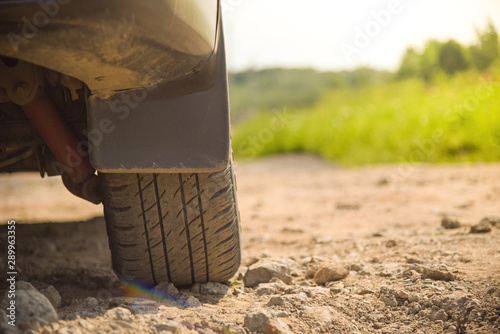 Close up view of car wheel.Transportation concept.wheel with summer tires close-up on background of summer landscape.green grass against background of wild nature.Outdoors travel. copy space.