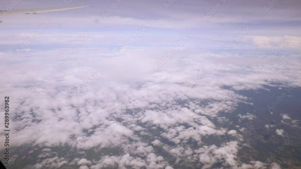 A view of the upper plane window while floating in the air, overlooking the mountains and natural water resources along the coast of Thailand.