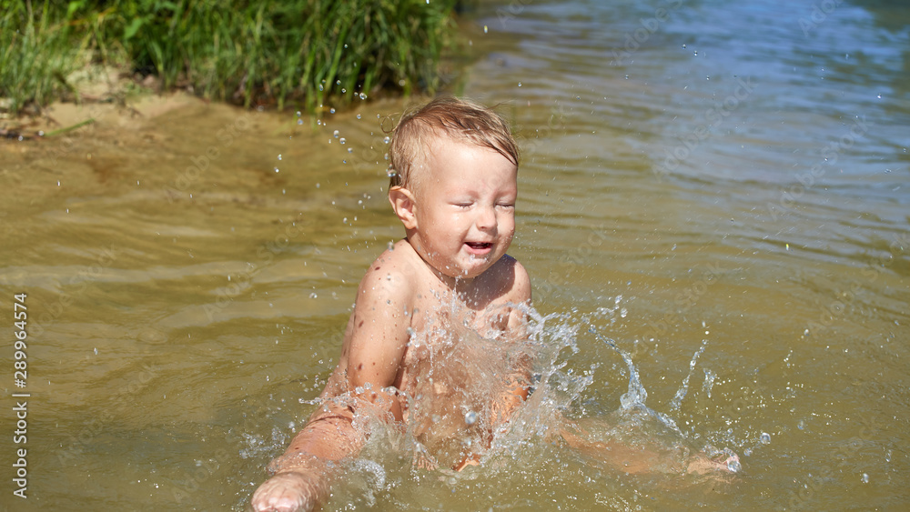 Cheerful carefree kid swimming in the water near the shore Cheerful carefree kid swimming in the water near the shore