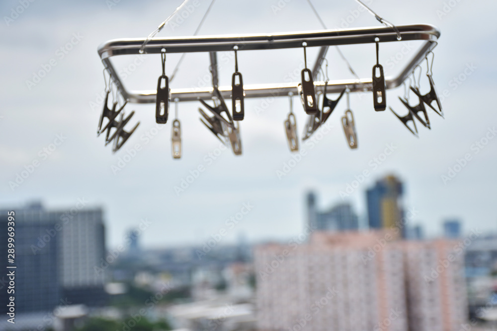 Naklejka premium Clothespin hanging on a skyscraper background.