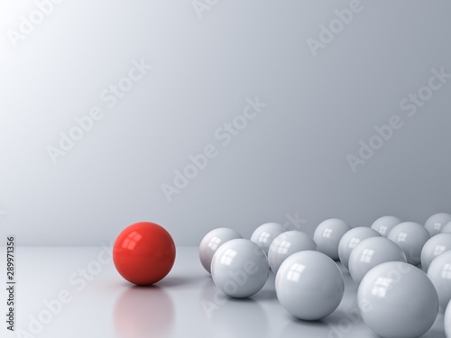 Leadership concept one red sphere leading whites over white room background with reflections and shadows 3D rendering