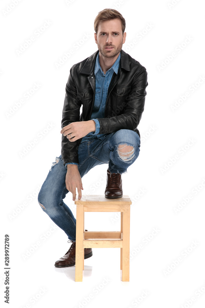 man standing with one leg down and one on chair Stock-Foto | Adobe Stock