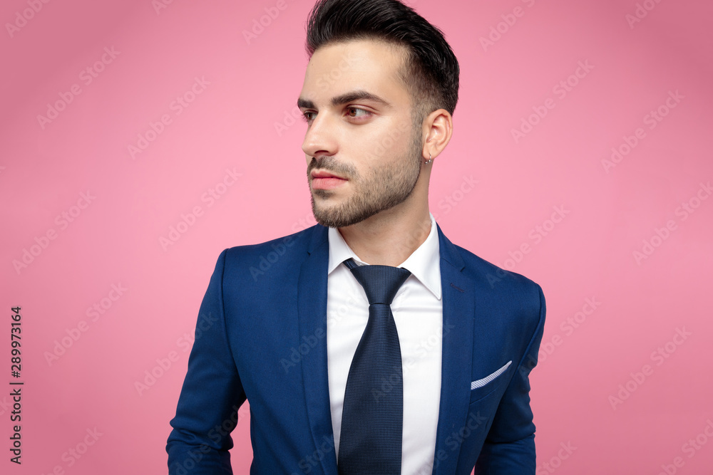 attractive young man looking to side on pink background attractive young man looking to side on pink background