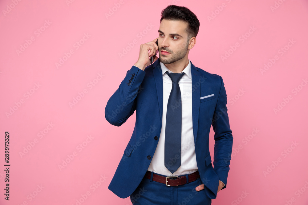 smart casual man talking on the phone on pink background smart casual man talking on the phone on pink background