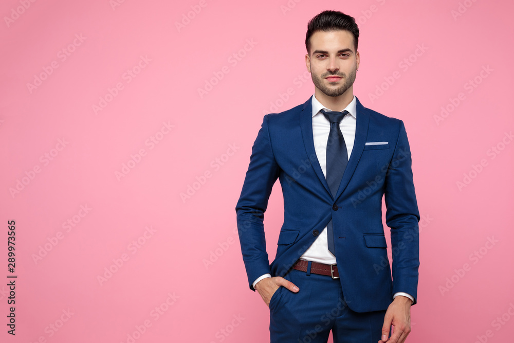 attractive young man wearing navy blue suit on pink background attractive young man wearing navy blue suit on pink background