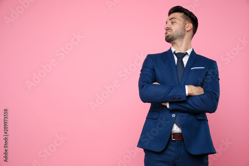 Obraz na plátně handsome young man crossing arms on pink background