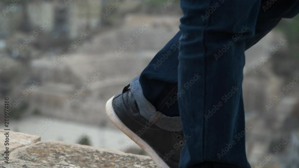 clouseup of man's feet walking on front of amman city citadel landscape clouseup of man's feet walking on front of amman city citadel landscape