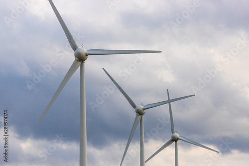 some modern wind turbines in front of a cloudy sky