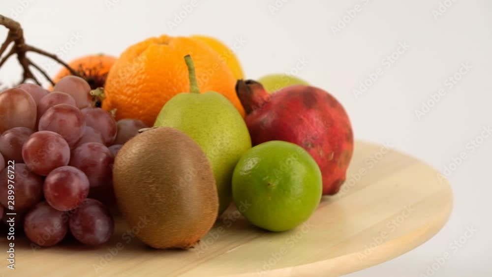exotic fruits on the table. Oranges, Pomegranate, Pear, Rambutan rotate on a cutting board exotic fruits on the table. Oranges, Pomegranate, Pear, Rambutan rotate on a cutting board