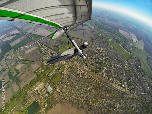 Hang glider pilot fly high above town and railroad station. photo