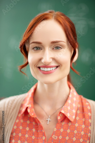 Appealing red-haired teacher smiling while feeling excited