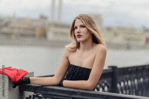Outdoor portrait of beautiful young woman with red scarf.