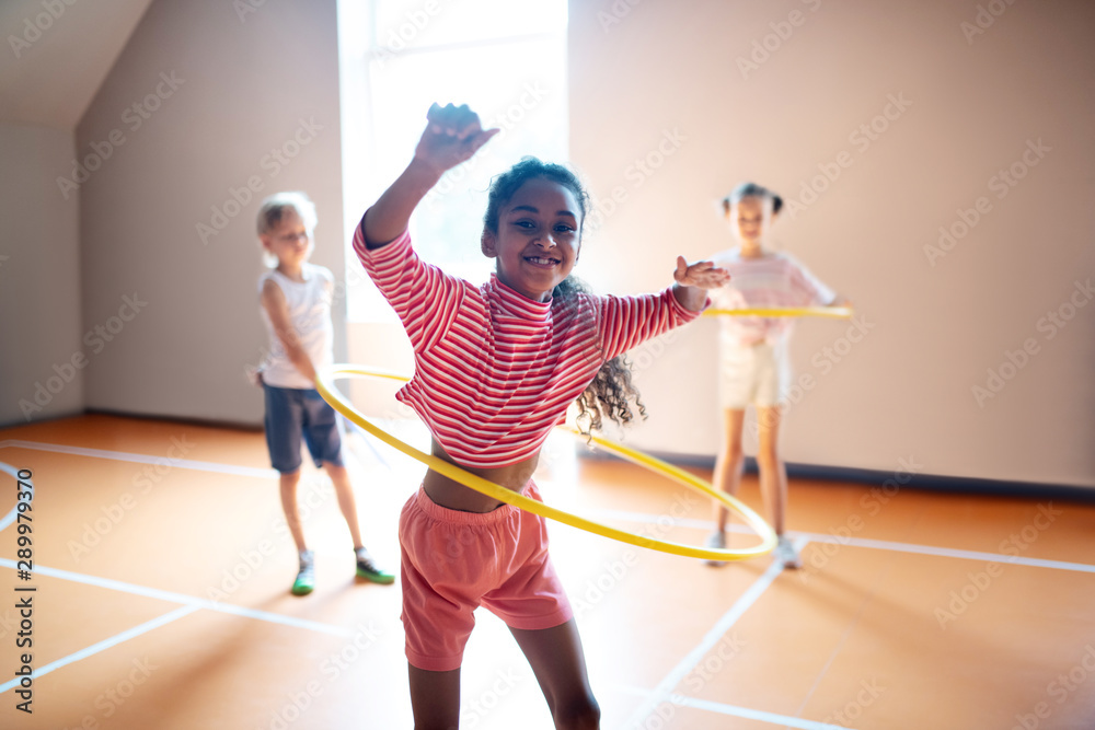 Cheerful curly girl enjoying active PE lesson