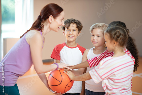 PE teacher and children smiling before starting basketball game