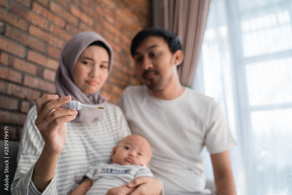 Obraz premium parent using thermometer to check their son condition at home